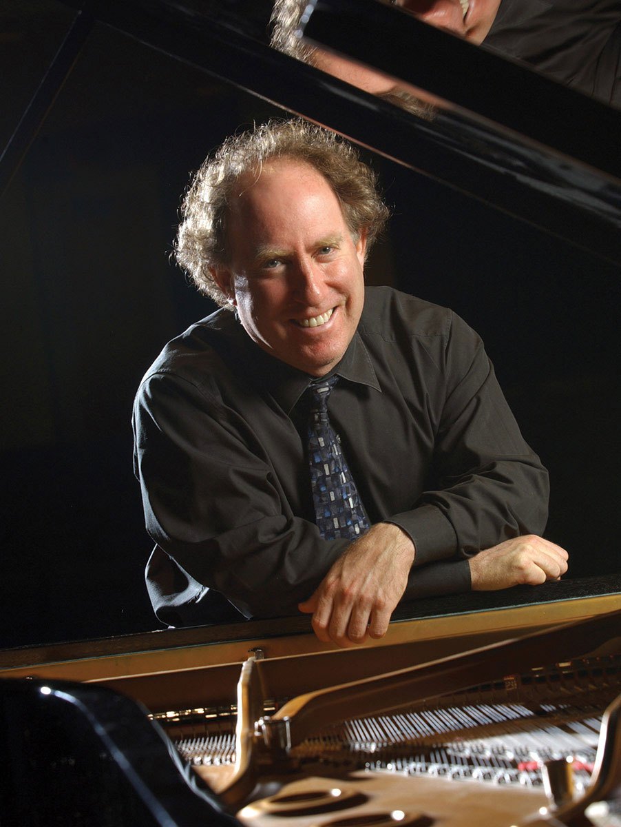 Jeffrey Kahane leaning on an open concert grand piano