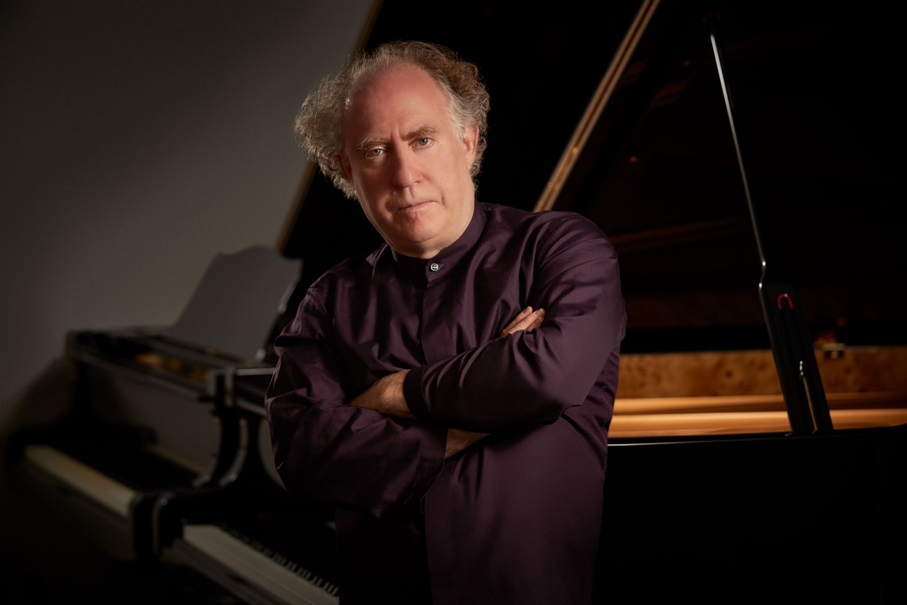Jeffrey Kahane standing beside a concert grand piano
